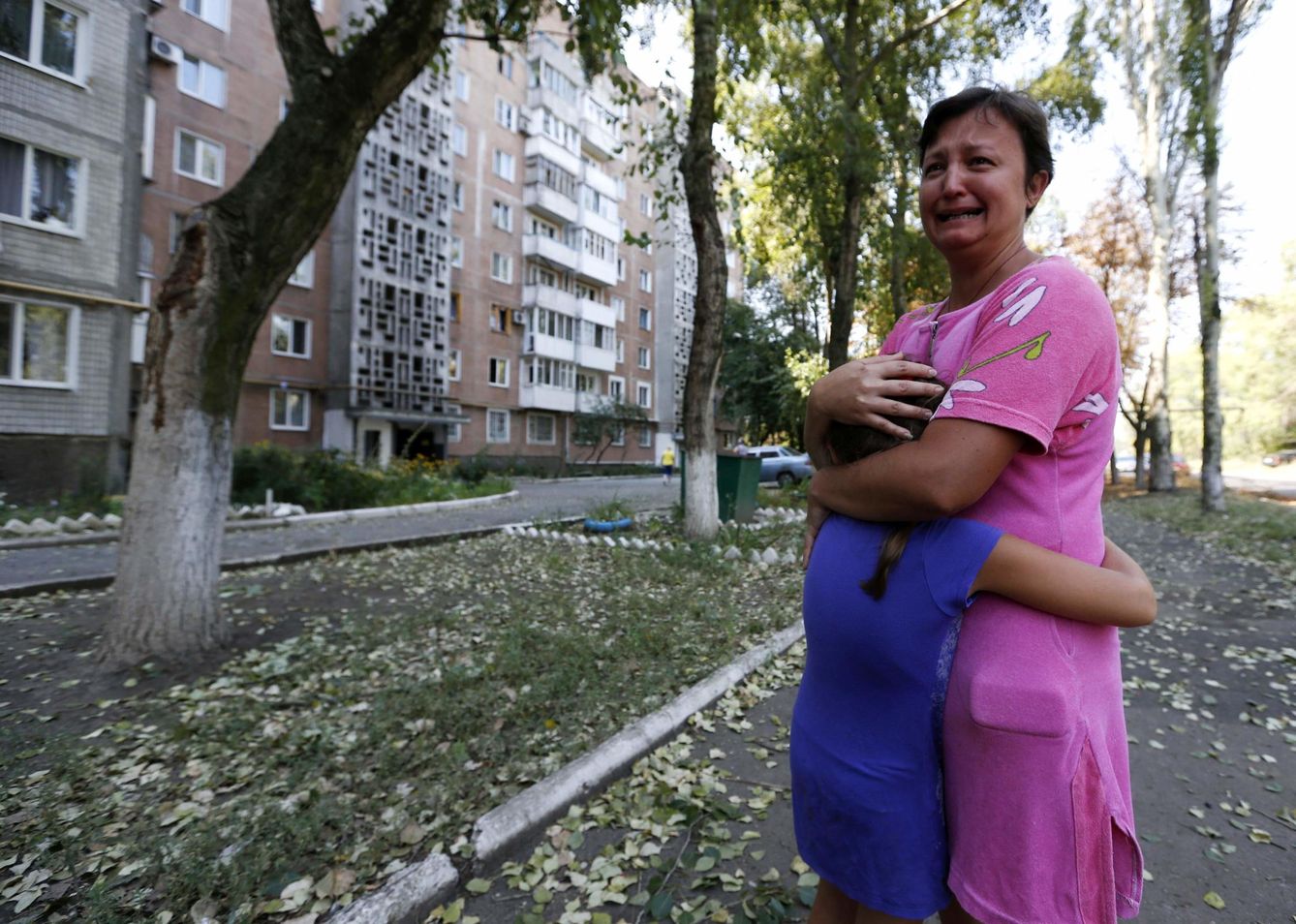 Una mujer protege a su hija tras un bombardeo ucraniano contra un edificio residencial de Donetsk (Reuters).