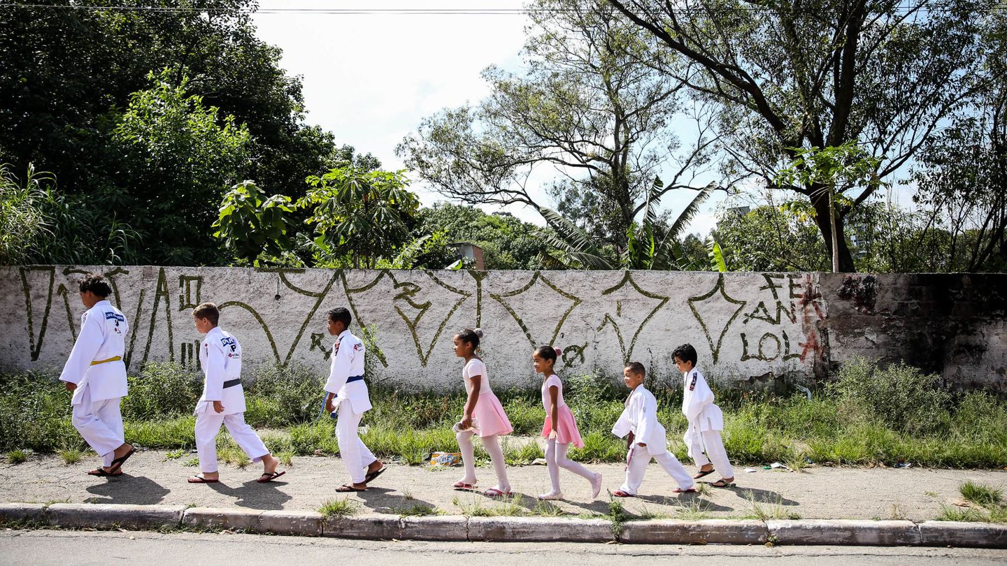 Un grupo de niños que caminan hacia sus clases de judo y ballet, en Vila Andrade. (EFE)