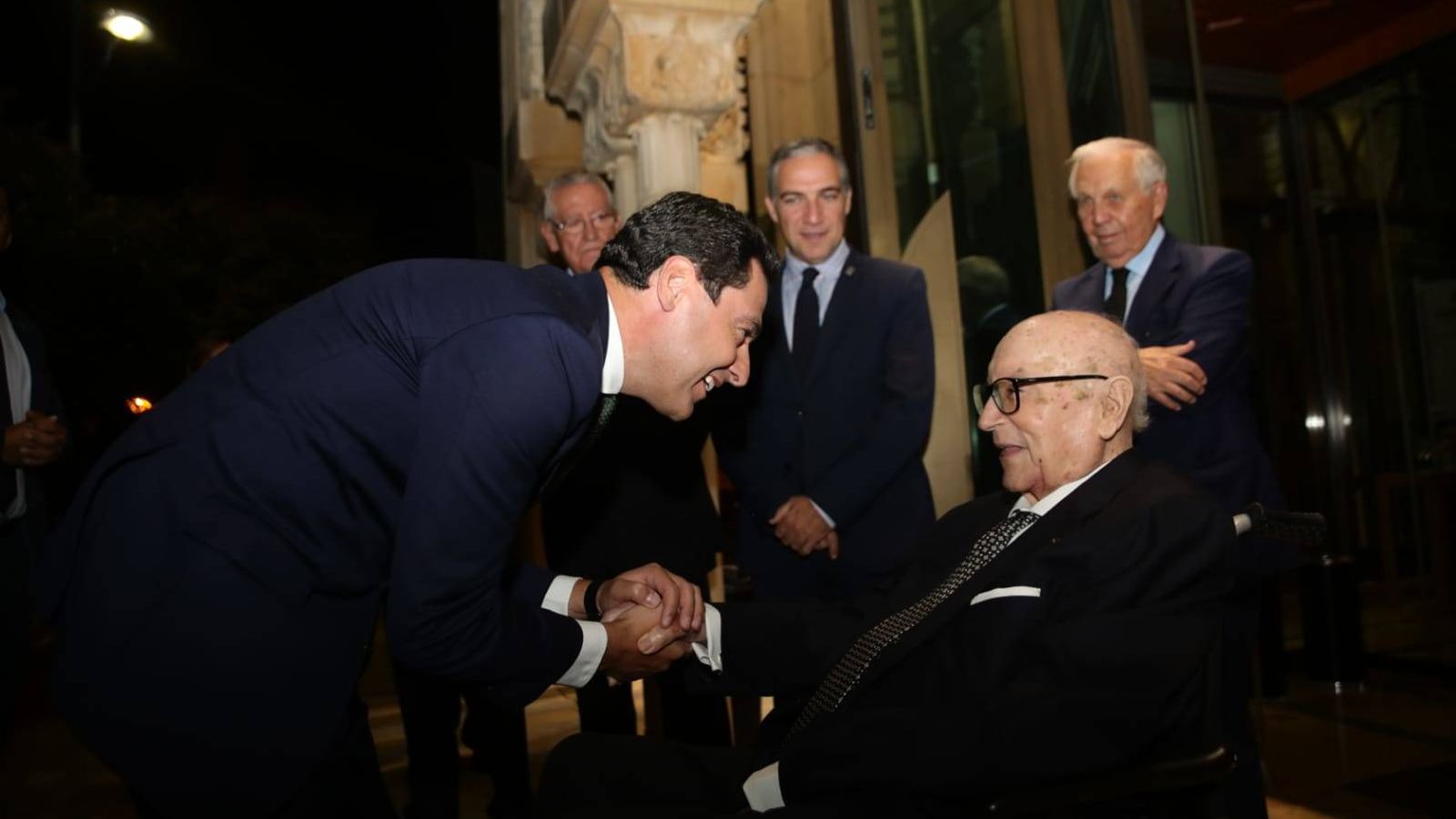 Foto: Imagen del homenaje a Manuel Clavero en Andalucía, con Juan Manuel Moreno, presidente de la Junta de Andalucía saludando a Clavero. (Fundación Rafael Escuredo)