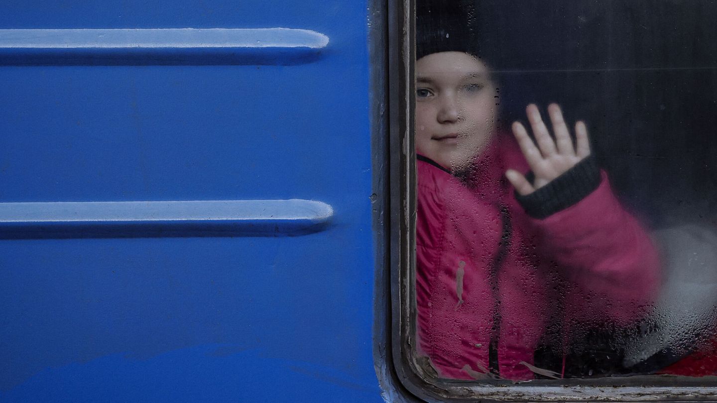 Un niño se despide de un familiar montado en un tren que parte desde Odesa. (EFE/ Manuel Bruque)
