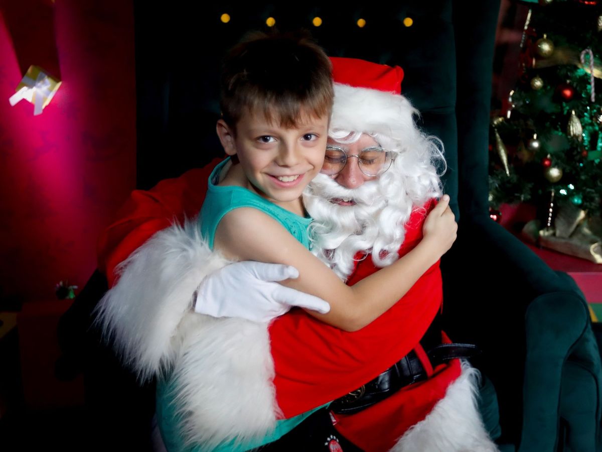 Foto: Un niño abraz a Papá Noel en un parque navideño de Buenos Aires (Argentina)