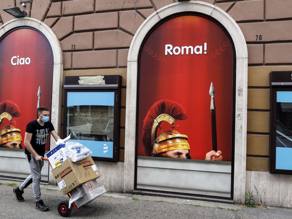 Foto: Un trabajador camina frente a una tienda en Roma. (EFE)