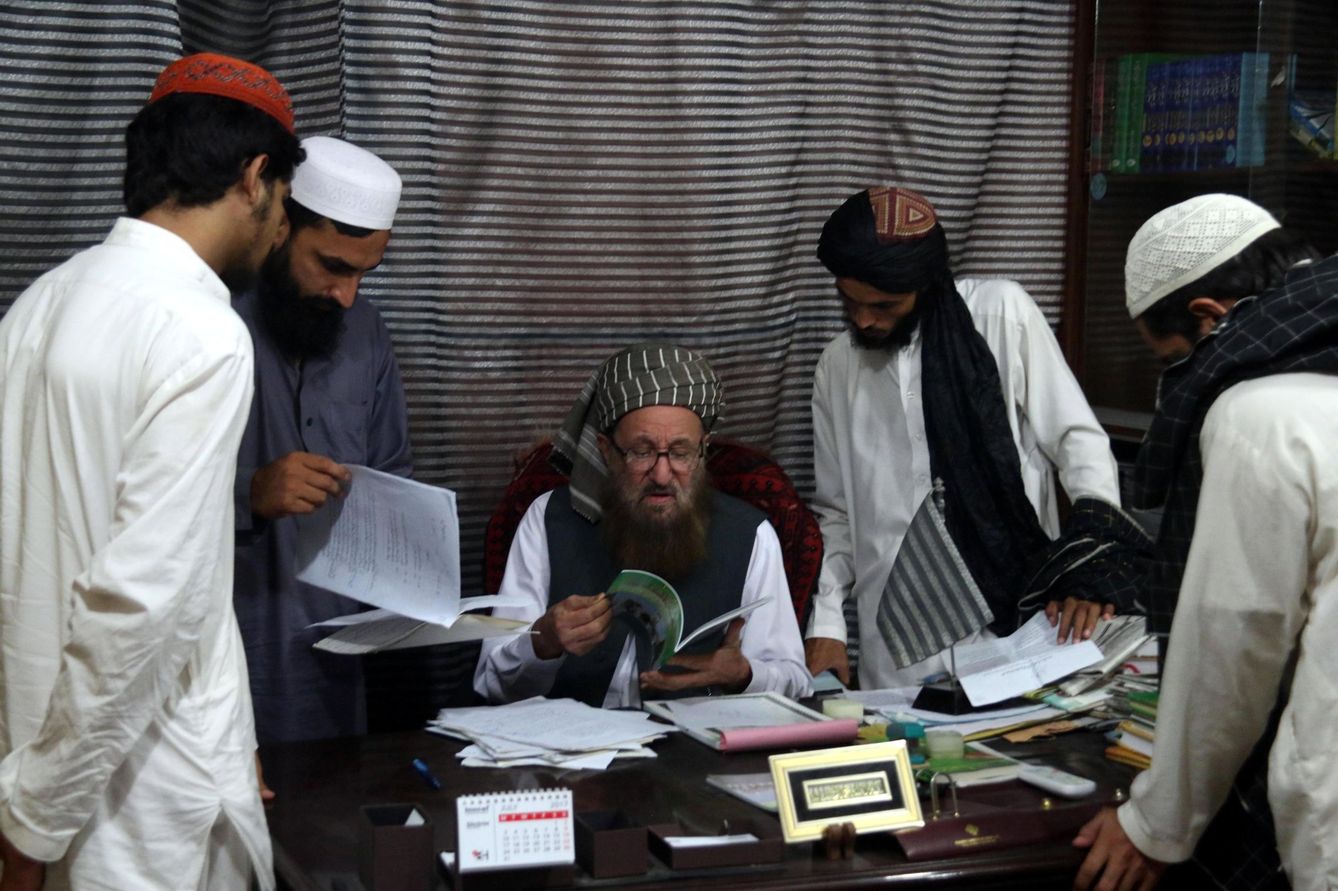 El maulana Sami ul Haq enseña un libro a unos estudiantes en la madrasa Darul Uloom Haqqania, bautizada como la 'universidad de la yihad' de los talibanes. (EFE)