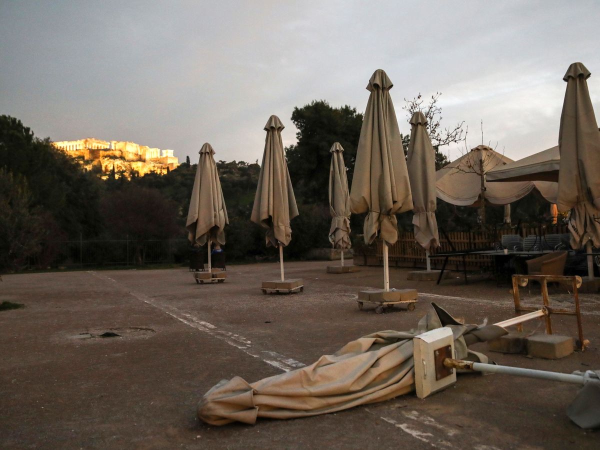 Foto: Una cafetería cerrada frente a la colina de la Acrópolis en Atenas. (Reuters)