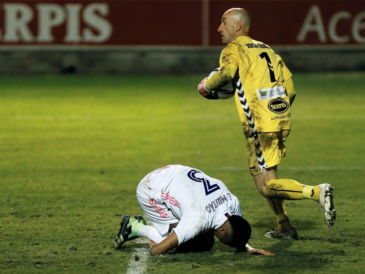 Foto: José Juan Figueiras coge un balón y Militao queda de rodillas. (EFE)