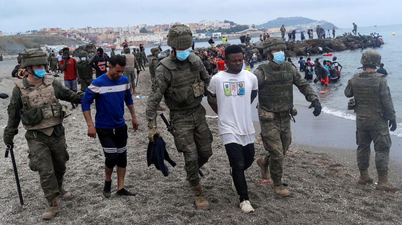 Foto: Miembros del Ejército de Tierra detienen a migrantes que han logrado cruzar la frontera de Ceuta. (Reuters)