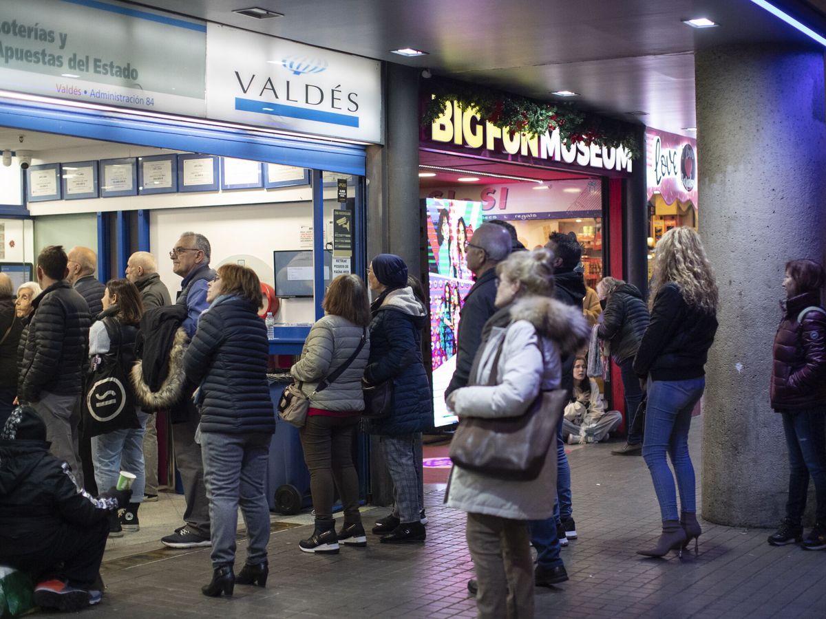 Foto: Los loteros catalanes esperan una buena campaña de venta de décimos del Sorteo Extraordinario de Lotería de Navidad a la vista de las largas colas de clientes que estos días se acumulan a las puertas de sus administraciones. (EFE/Marta Pérez)