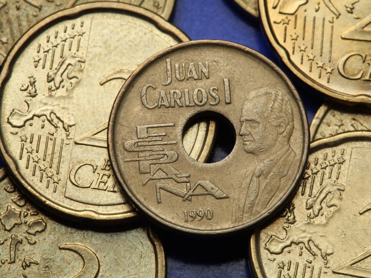 Foto: Una moneda de 25 pesetas al lado de otras de 20 de céntimos de euro (iStock)