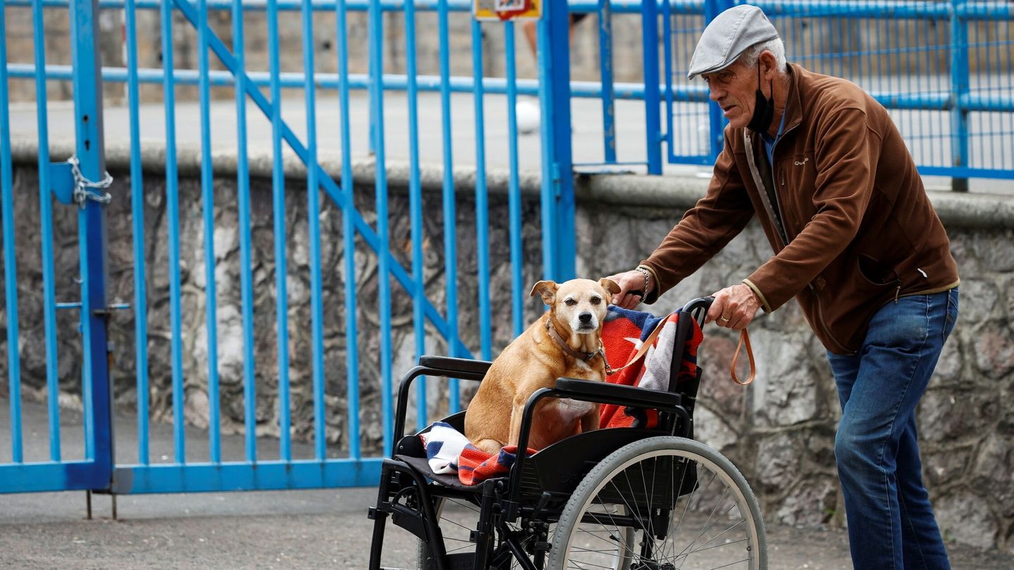 Un hombre pasea a su perro junto a una residencia de ancianos de San Sebastián. (EFE/Javier Etxezarreta)