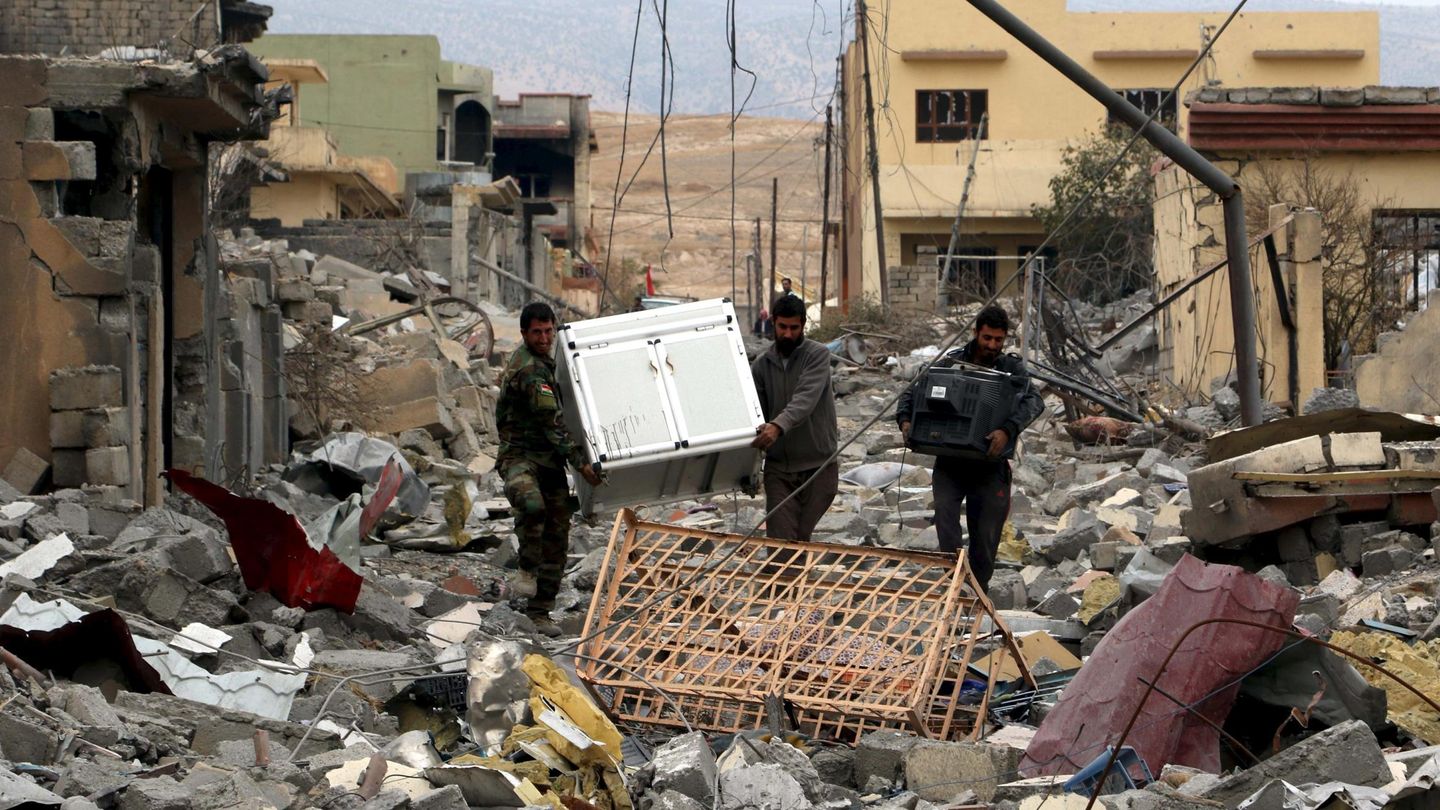 Voluntarios yazidíes transportan objetos recuperables en Sinjar, en noviembre de 2015 (Reuters)