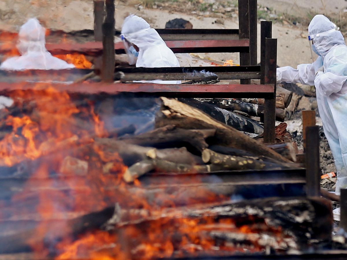 Foto: Últimos rituales de familiares en un entierro de una persona fallecida por covid. (Reuters)