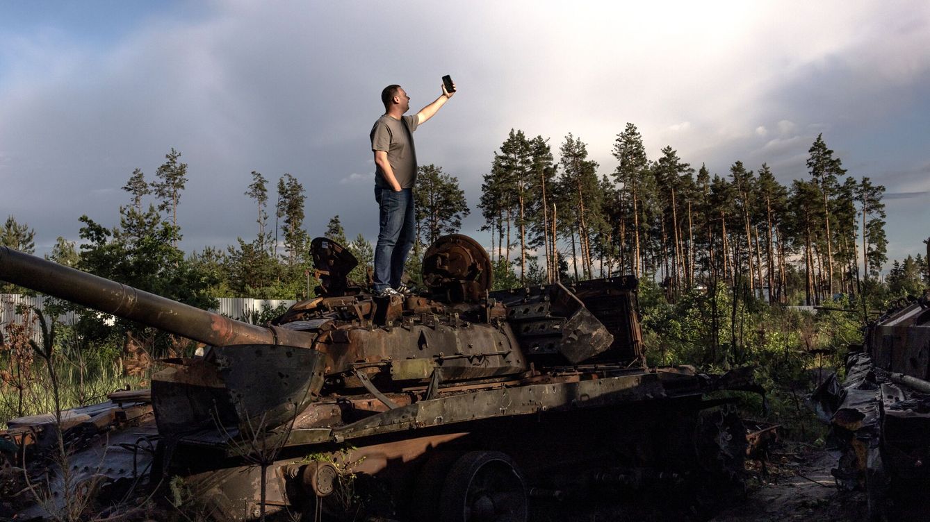 Foto: Un hombre se hace una foto encima de un tanque ruso destruido en la región de Kiev. (EFE/Roman Pilipey)
