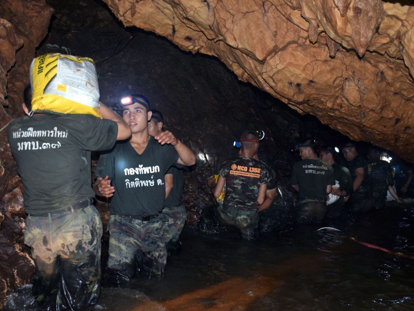 Varios miembros de un equipo de rescate meintras intenta drenar el agua de la cueva Tham Luang en Khun Nam Nang Non Forest Park. (EFE)