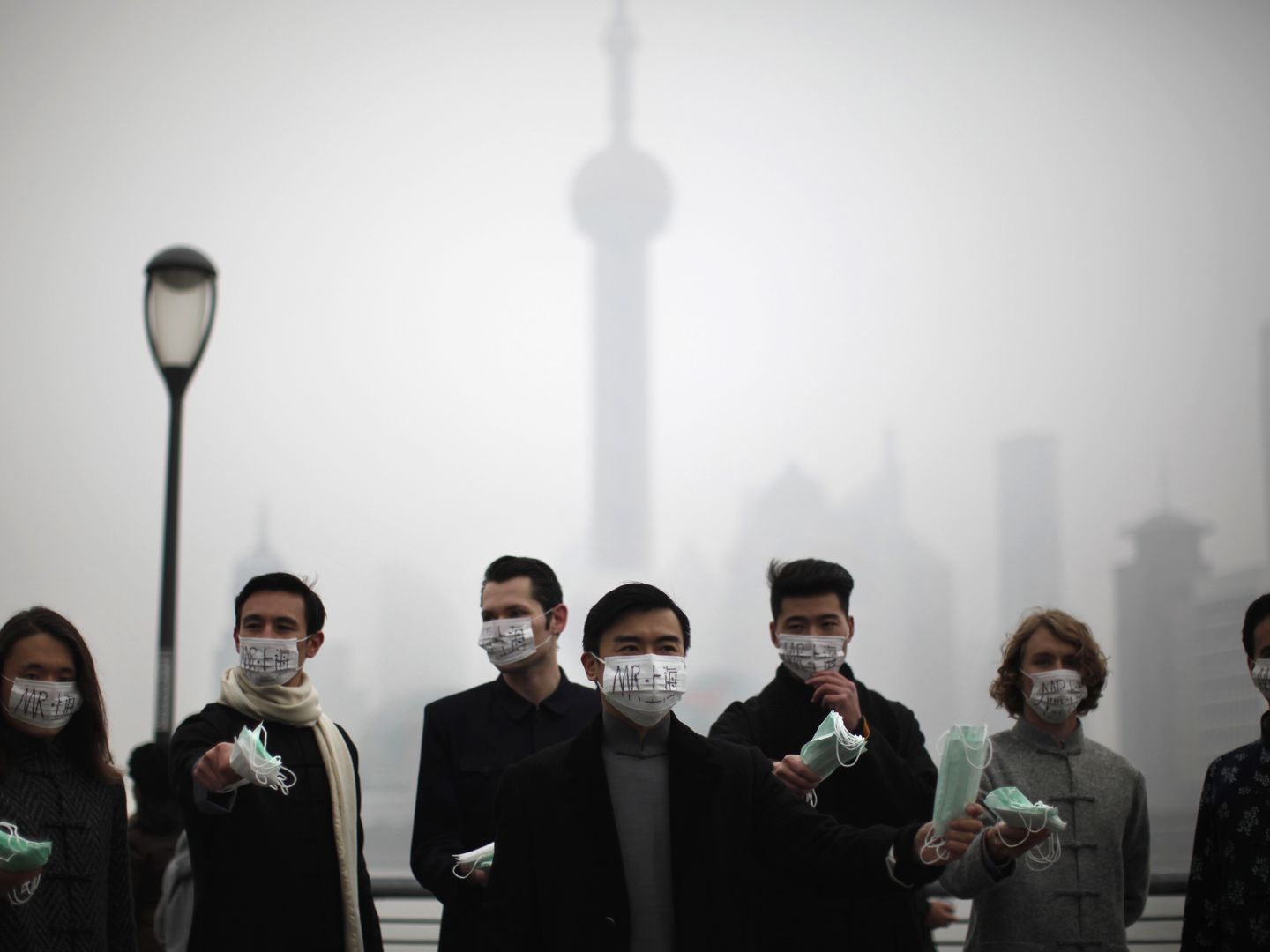 Un grupo de personas distribuye máscaras a los transeúntes en el centro de Shangái (Reuters).