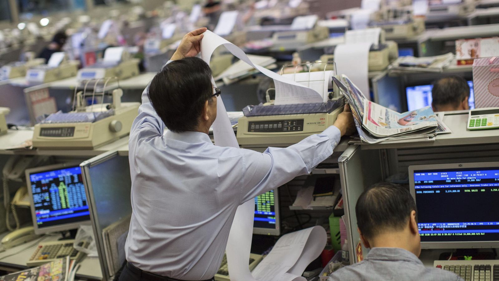 Foto: Un corredor de bolsa imprime la lista con las transacciones del día en la Bolsa de Hong Kong. (EFE)