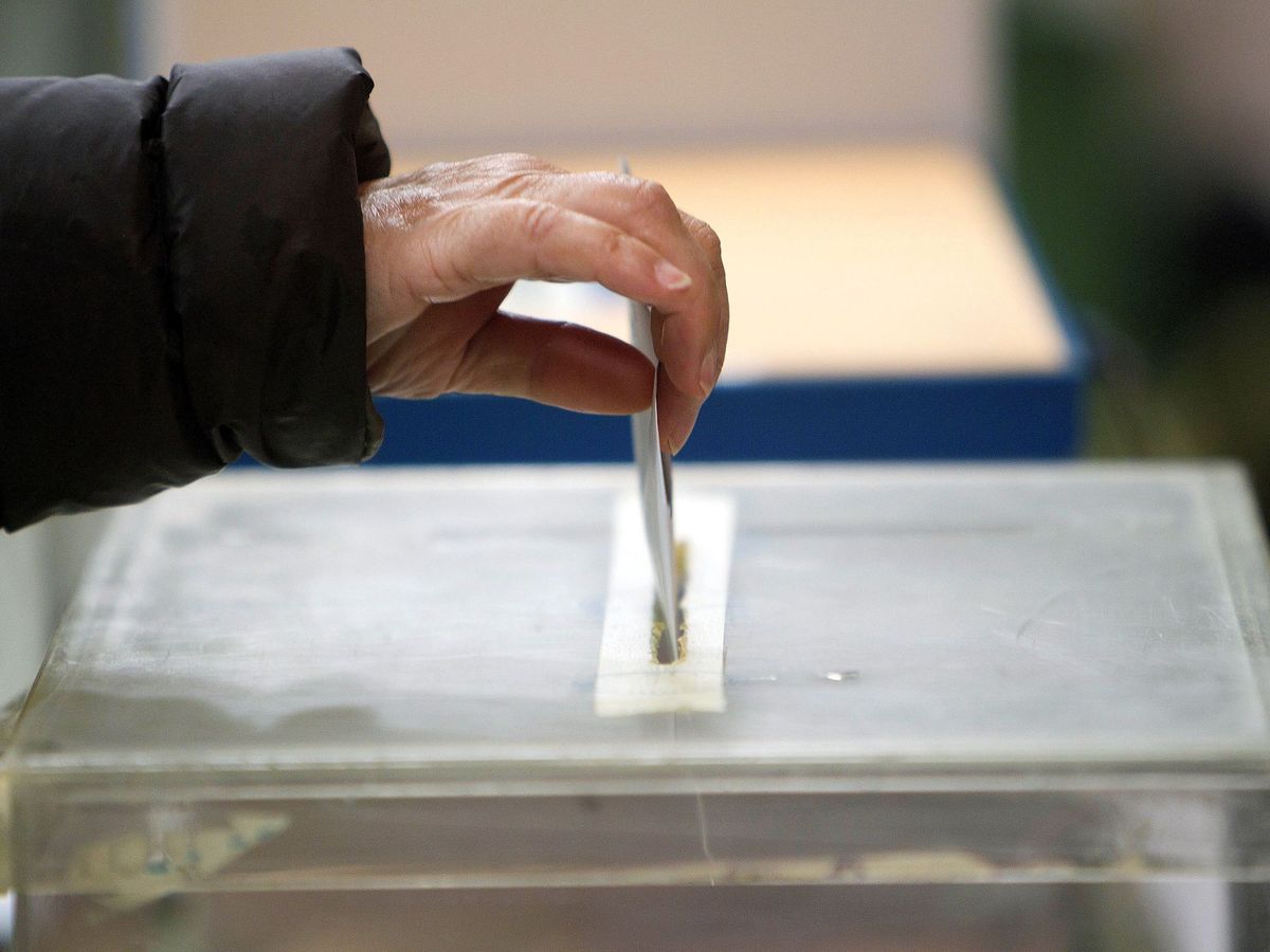 Foto: Una persona deposita una papeleta en un colegio electoral en Vigo. (EFE)