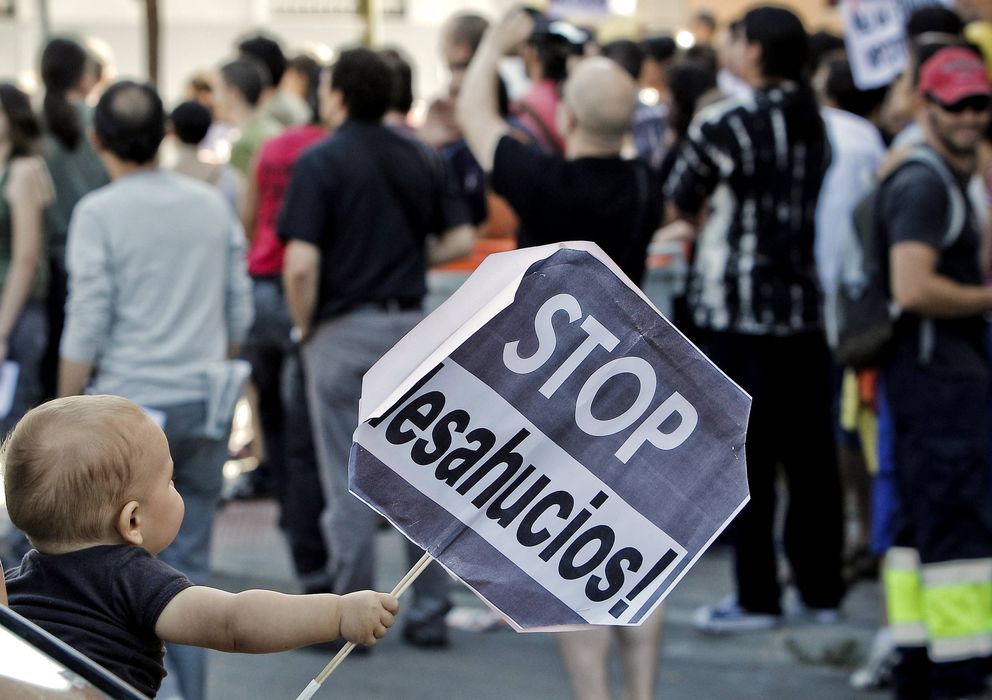 Foto: Un niño sujeta un cartel en una concentración en Carabanchel para evitar el desahucio de una vecina. (EFE)