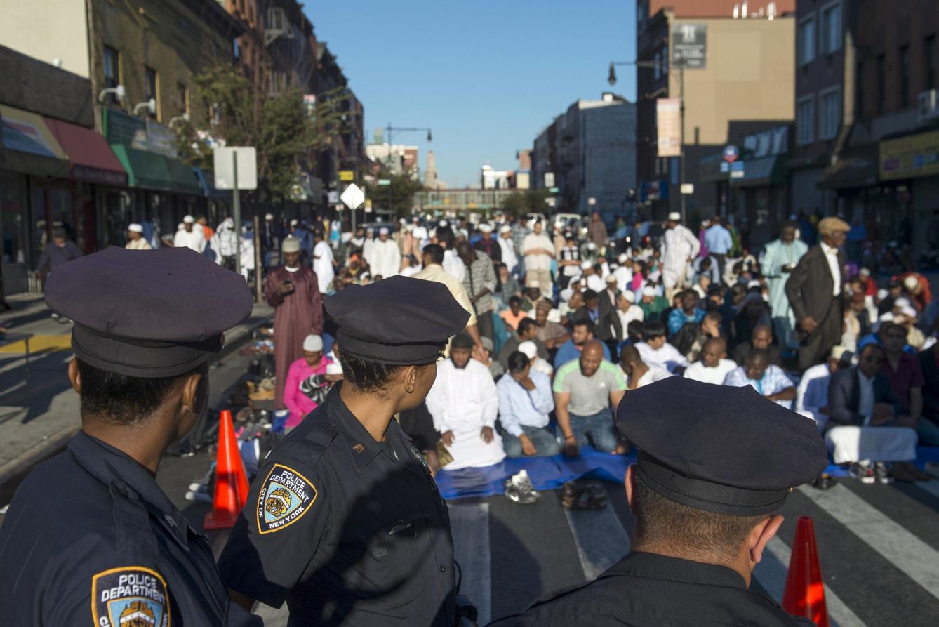 Foto: Agentes de la policía de Nueva York observan a musulmanes durante el rezo ante la mezquita Masjid At-Taqwa, en Brooklyn. (Reuters)