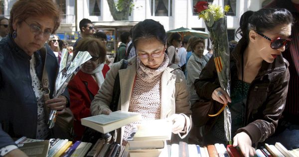 Foto: Un grupo de mujere observa libros en Barcelona durante la festividad de Sant Jordi. (EFE)