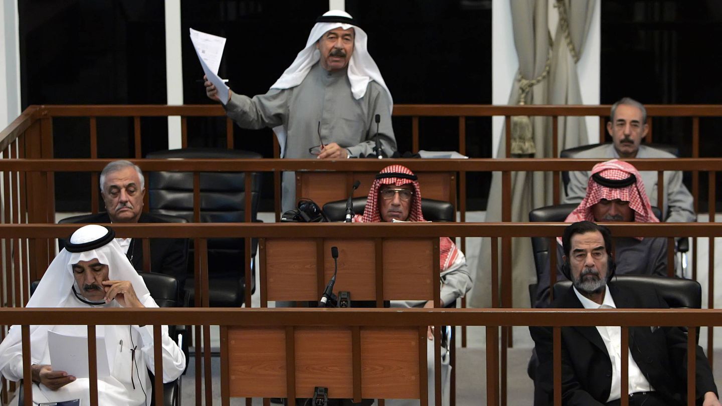 Alí Hassan Al Mayid, 'Alí el Químico', habla durante su juicio en octubre de 2006. Abajo a la derecha, su primo, Saddam Hussein. (Reuters)
