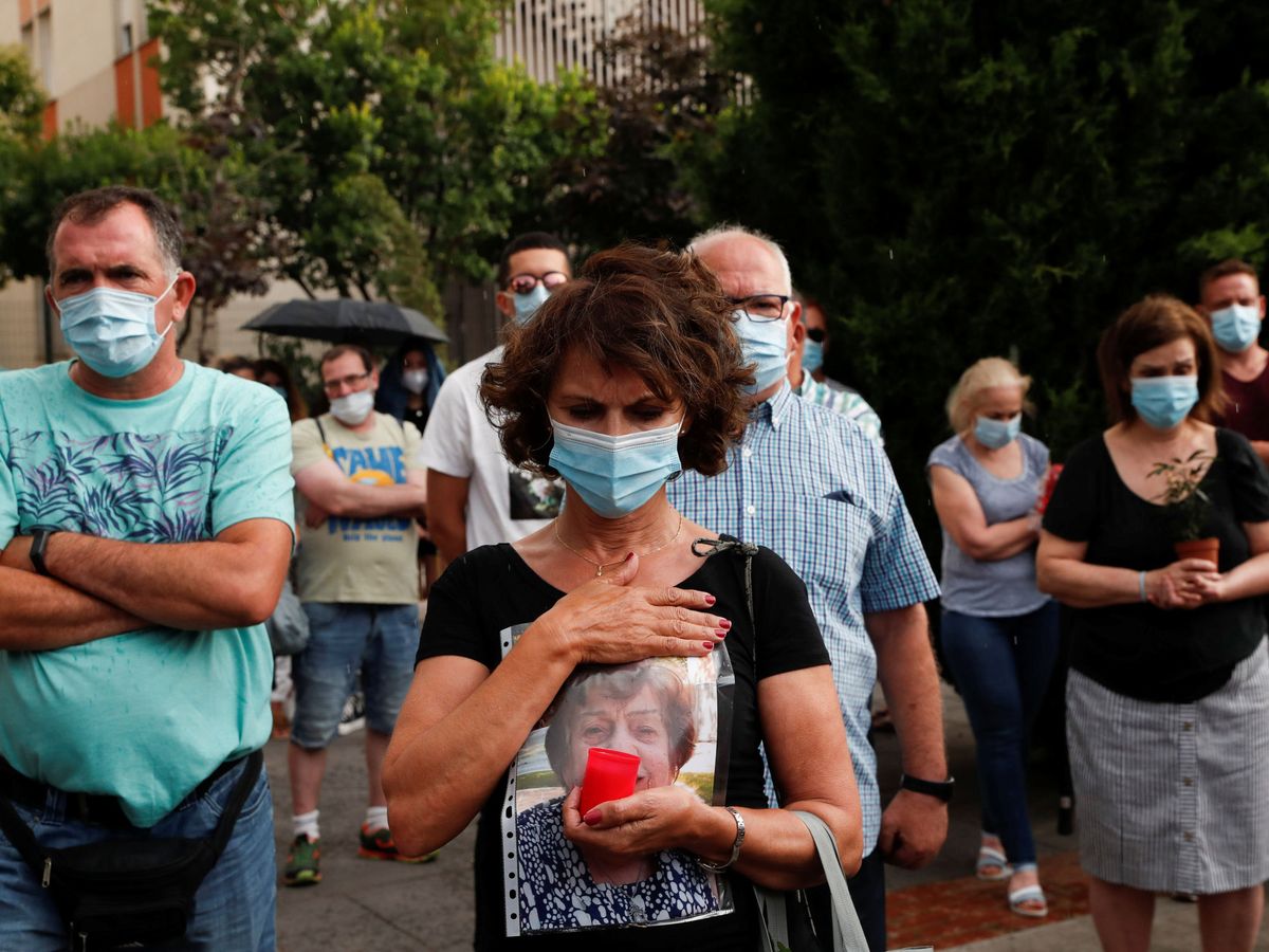 Foto: Familiares y amigos rinden homenaje a los fallecidos por coronavirus en una residencia de Leganés (Madrid). (Reuters)