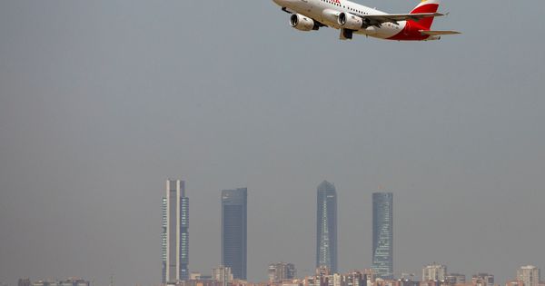 Foto: Un avión de Iberia despega. Al fondo, una panorámica del cielo de Madrid donde se aprecia la boina de contaminación. (Reuters)