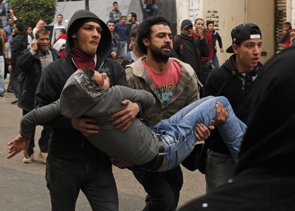 Uno de los manifestantes, herido, es transportado por sus compañeros (Reuters)
