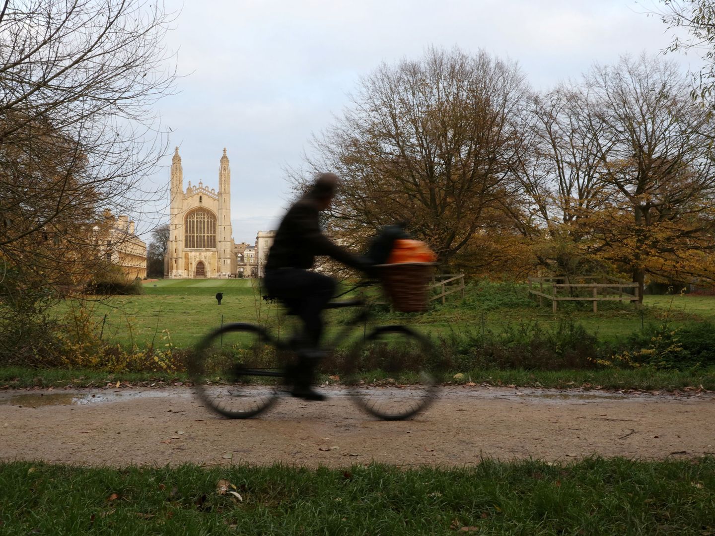 Un ciclista pasea por los alrededores de Cambridge con el King's College de fondo, uno de los pocos colegios no involucrados en las inversiones.