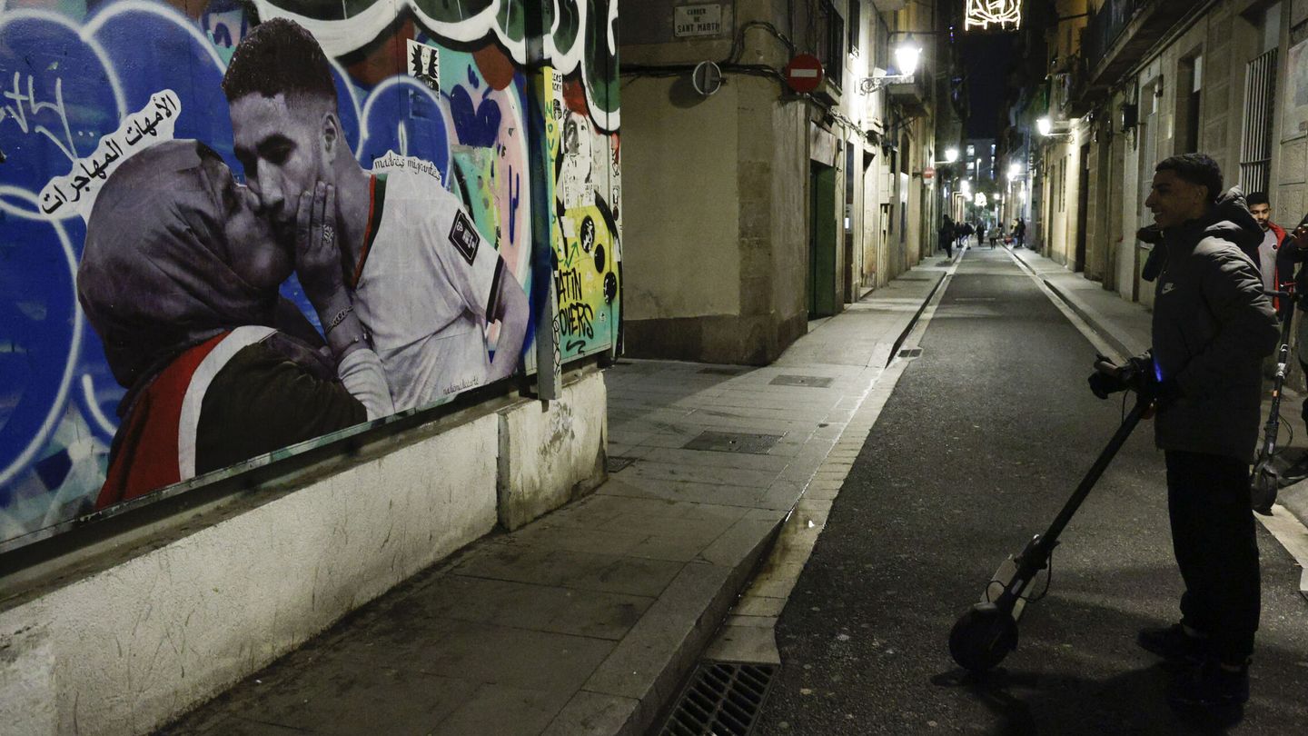 Un joven observa un grafiti de Achraf Hakimi y su madre en el barrio del Raval de Barcelona. (EFE)