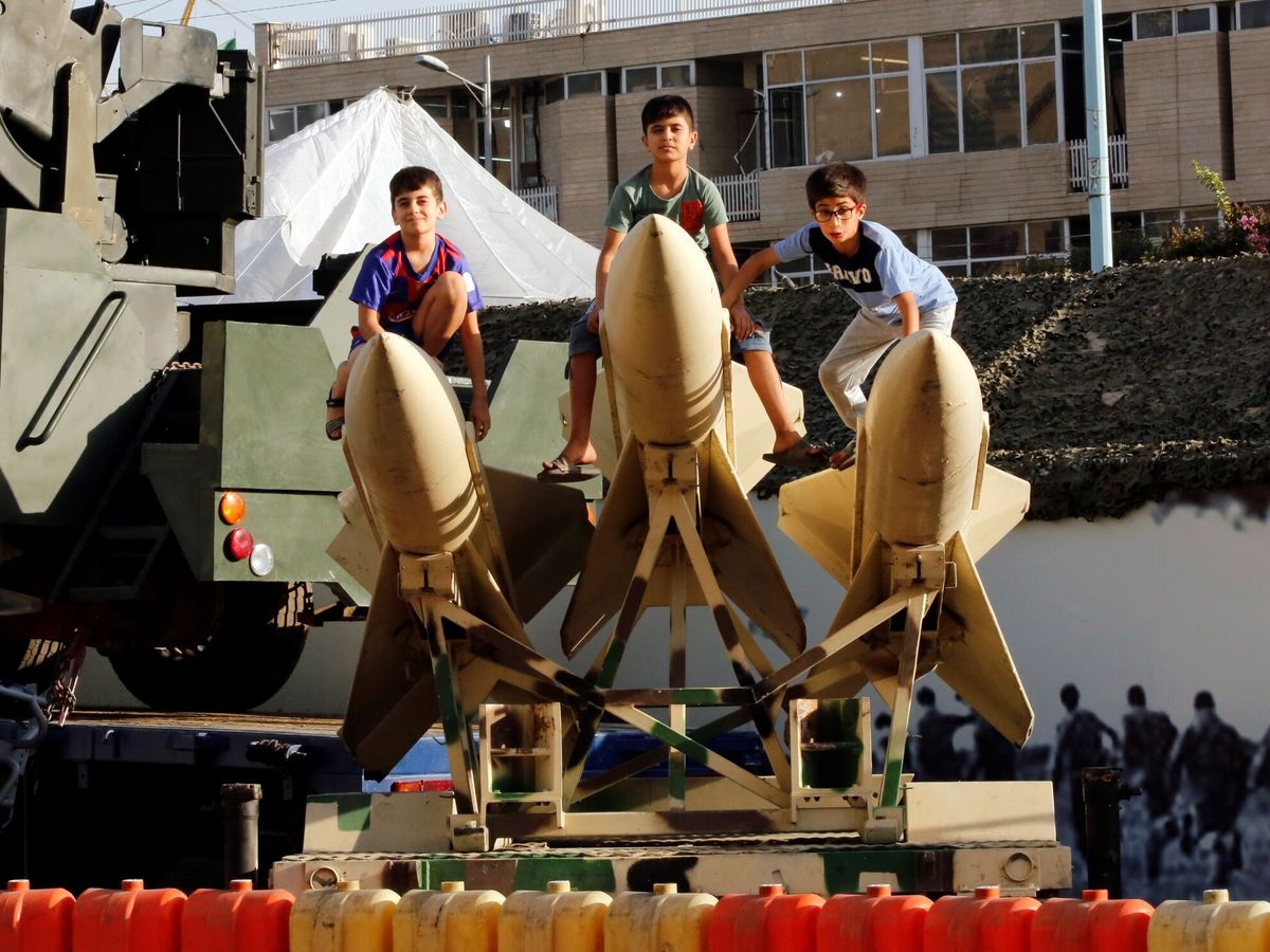 Foto: Unos niños se suben a unos misiles de corto alcance expuestos por el ejército iraní con motivo de las celebraciones de la Semana de la Defensa. (EFE/Abedin Taherkenareh)