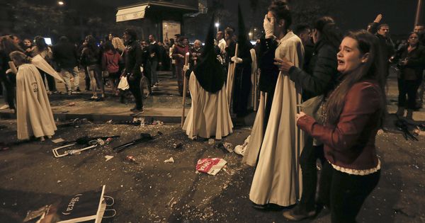 Foto: Nazarenos de La Esperanza de Triana tras sufrir la estampida en la Madrugá de Sevilla. (EFE)