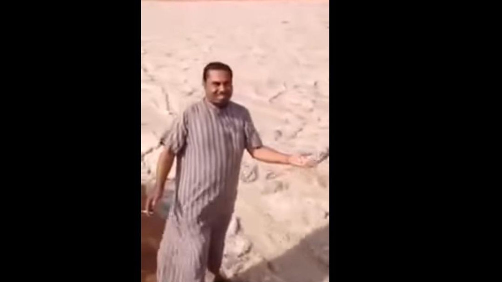 Foto: Un hombre toca la arena que forma este 'río' (captura de YouTube)