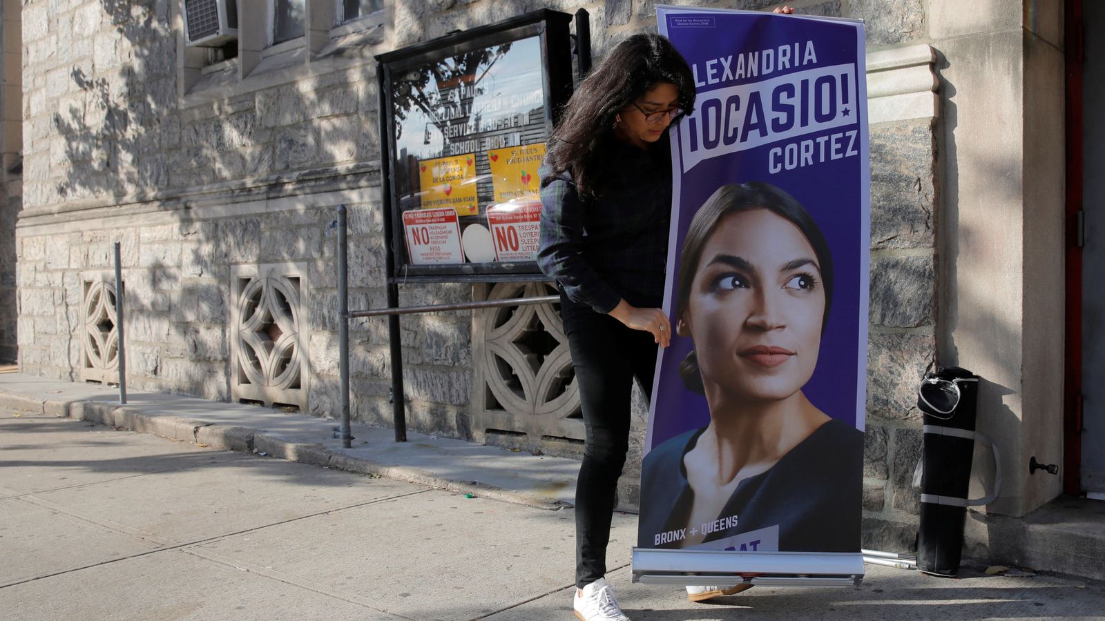 Foto: Una voluntaria de campaña coloca un cartel de Alexandria Ocasio-Cortez durante un evento en una iglesia del Bronx, Nueva York. (Reuters)