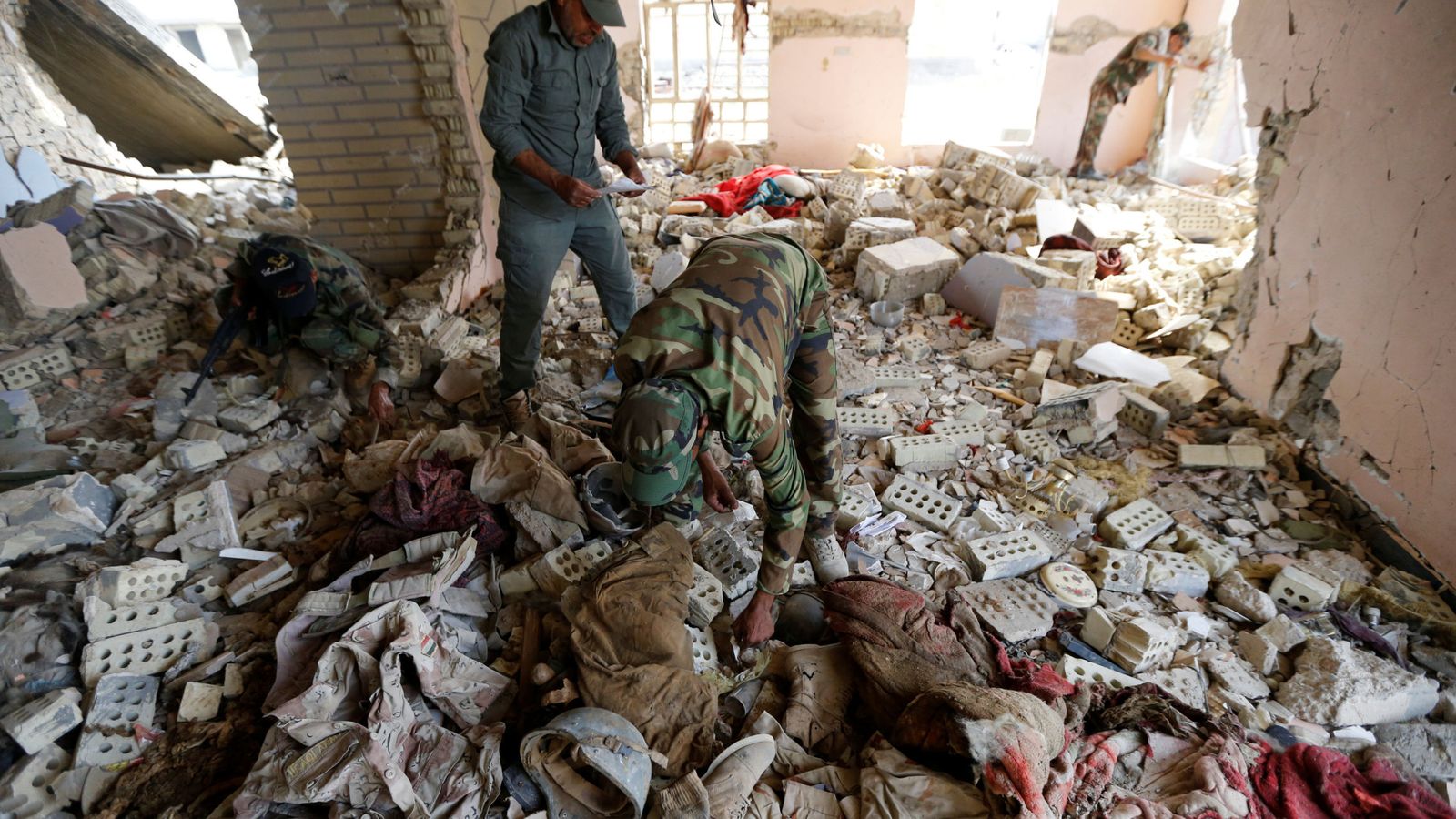 Foto: Milicianos chiíes examinan los cadáveres de miembros de las fuerzas de seguridad iraquíes asesinados por el ISIS en Saqlawiya, el 5 de junio de 2016 (Reuters)