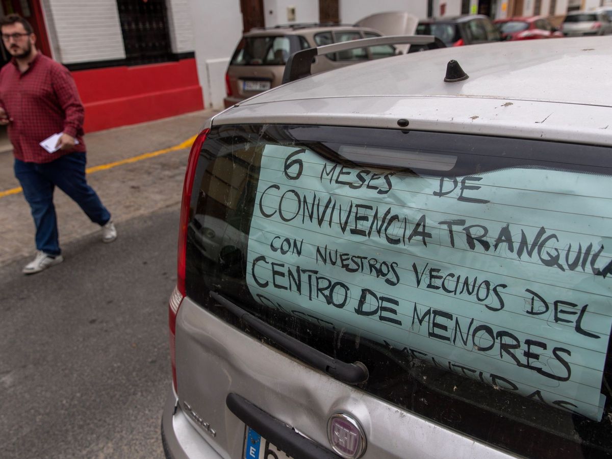Foto: Un coche con un cartel estacionado en la calle del barrio de la Macarena de Sevilla, donde está ubicado un centro de menores. (EFE)