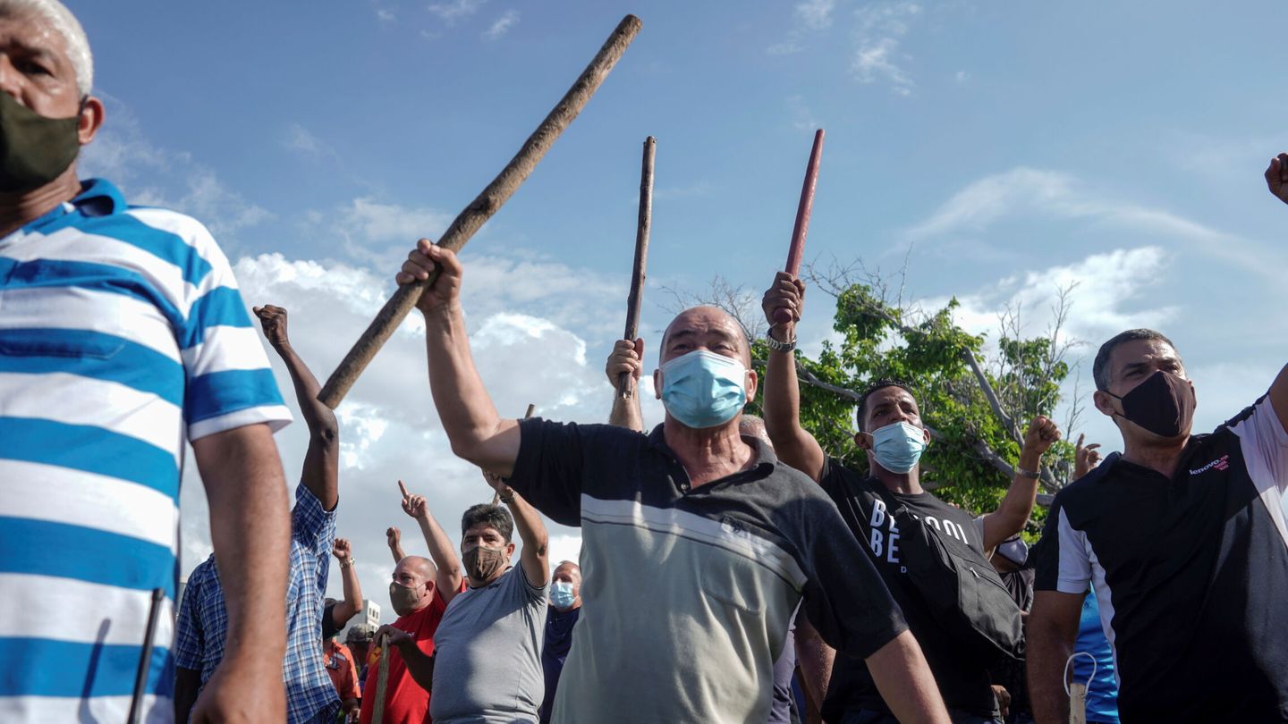 Manifestantes portando palos durante una marcha. (Reuters)