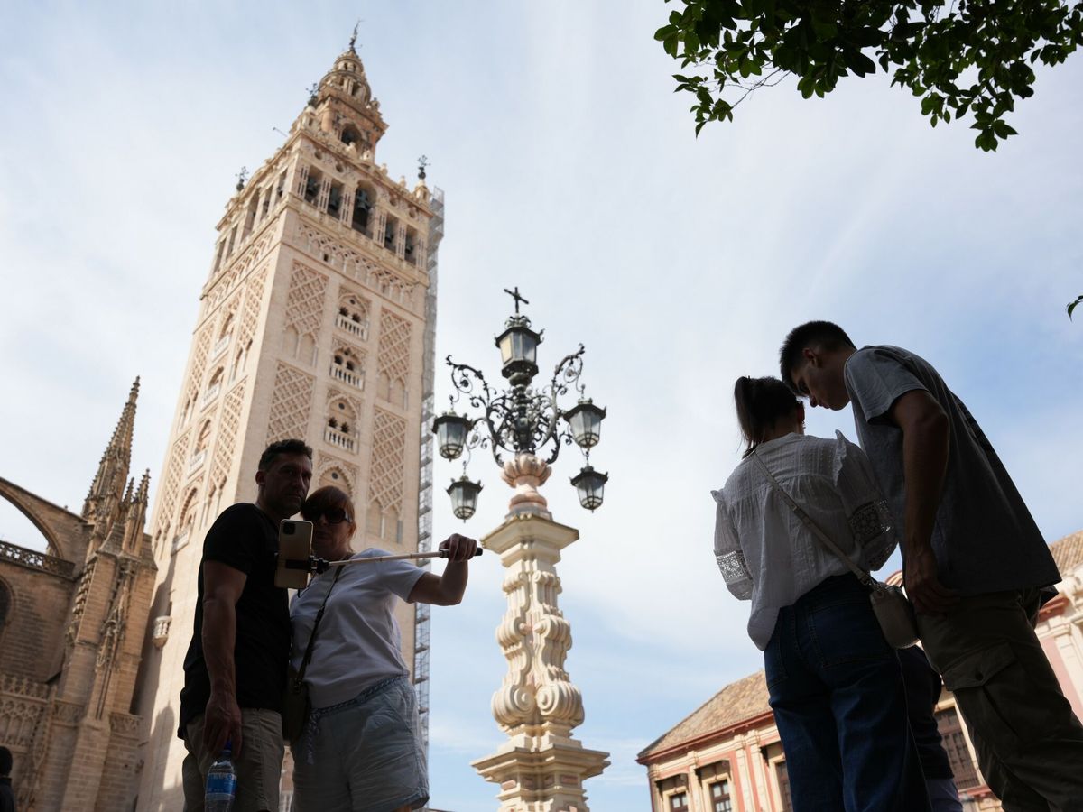 Foto: Turistas fotografiándose frente a la Giralda, en Sevilla, durante el puente del pasado 12 de octubre. (Europa Press/María José López)