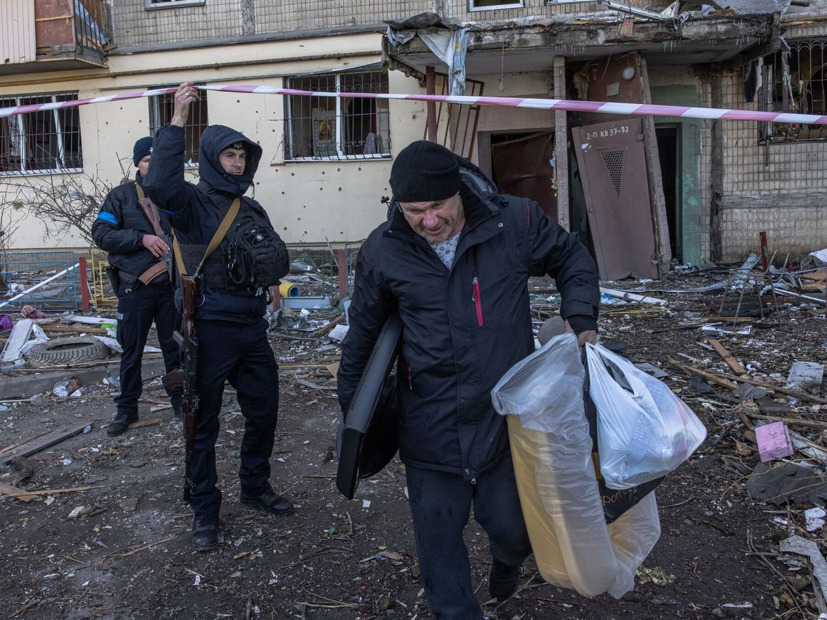 Foto: Un hombre transporta objetos del edificio residencial que fue alcanzado por un bombardeo en Obolon, en Kiev. (EFE/EPA/Roman Pilipey) 