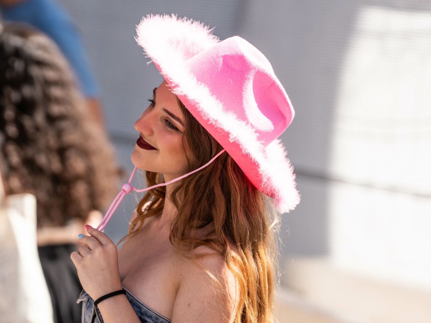 Una mujer son un sombrero rosa en la cola del merchandising de Taylor Swift, en los alrededores del Estadio Santiago Bernabéu, a 28 de mayo de 2024 (Matias Chiofalo / Europa Press)