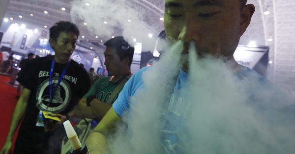 Foto: Un visitante prueba un cigarrillo electrónico en un stand de la feria "Vape China Expo" del cigarrillo electrónico