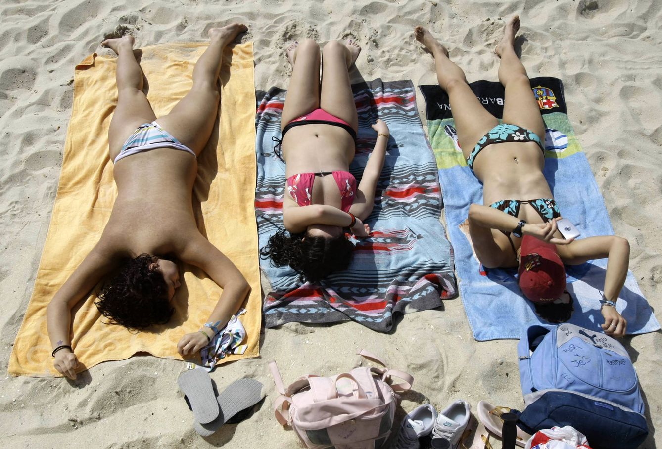 Tres mujeres toman el sol en la playa de Samil, en Vigo. (Reuters)