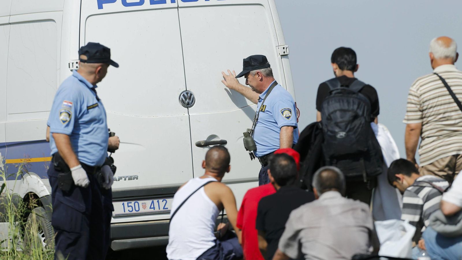 Foto: Un grupo de refugiados, con agentes de la policía croata (Reuters).