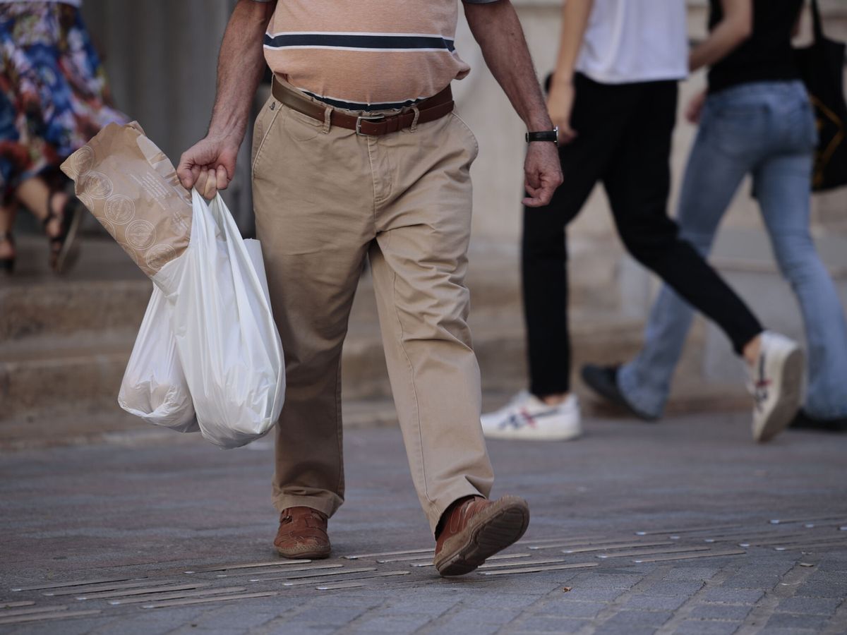 Foto: Un hombre, tras hacer la compra, en Valencia. (EFE/Biel Aliño)