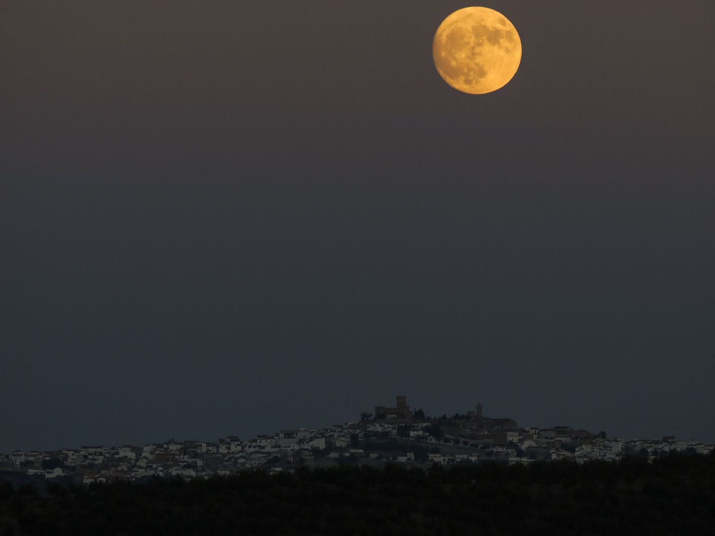 La luna llena sobre Espejo (Córdoba). (EFE/Fernando Villar)
