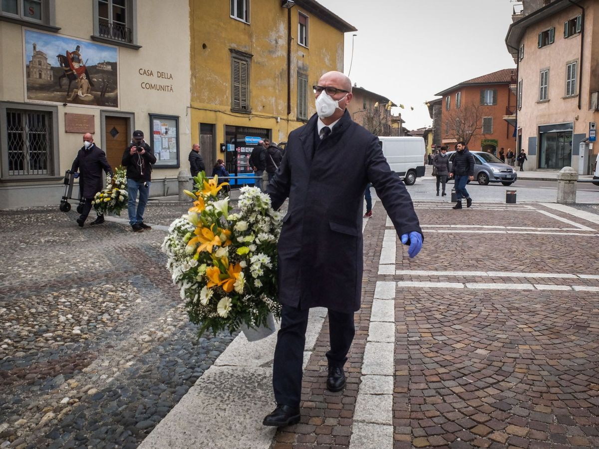 Foto: Un hombre porta una corona de flores y se cubre la boca con una mascarilla en Italia. (Reuters)