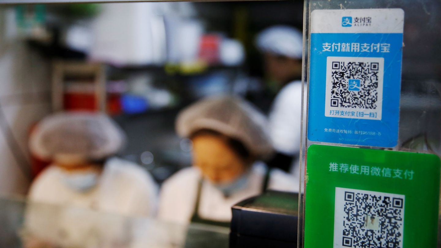 A QR code of digital payment device Alipay by Ant Group, an affiliate of Alibaba Group Holding, is seen next to a QR code of WeChat Pay at a food stall inside a market, in Beijing, China November 2, 2020. REUTERS Tingshu Wang