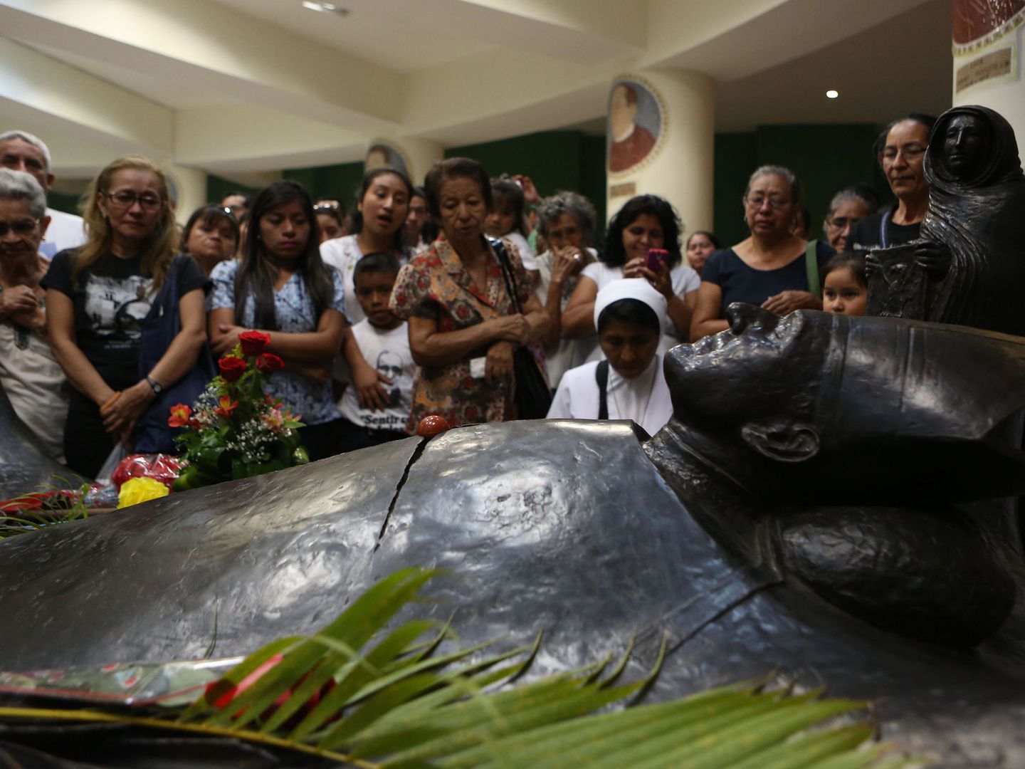  Varias personas rezan frente a la tumba del arzobispo Óscar Arnulfo Romero, en San Salvador, cuando se cumplen 37 años de su homicidio. (Efe)