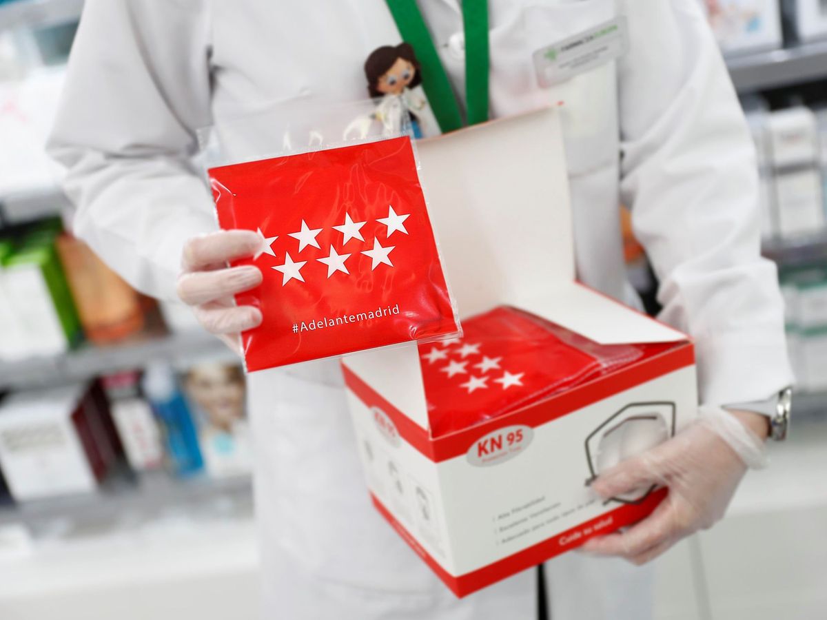 Foto: Un farmacéutico muestra un paquete de mascarillas KN95 distribuido por la Comunidad de Madrid. (EFE)