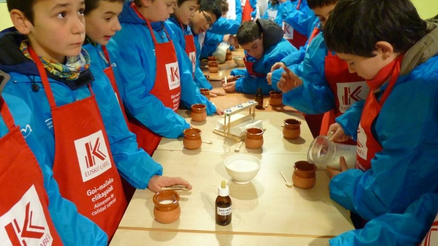 Niños aprenden a hacer cuajada en una visita escolar al caserío Gomiztegi de Oñati. (EC)
