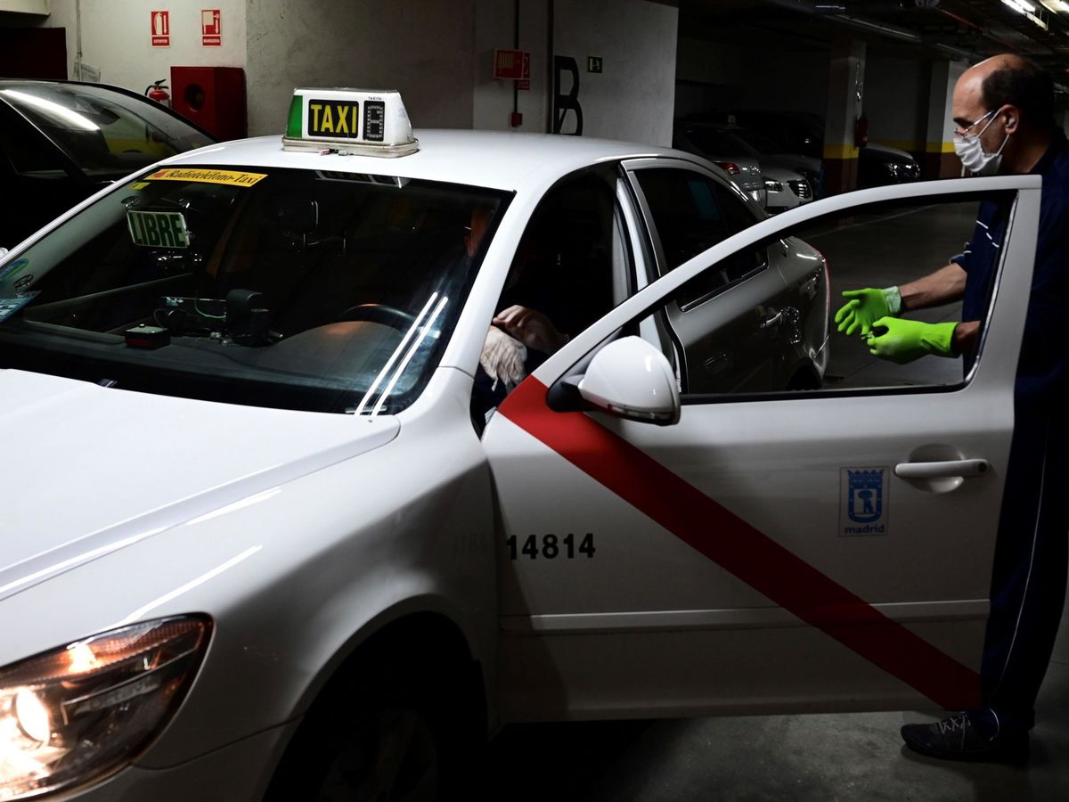 Foto: Un taxista efectúa las medidas de limpieza y protección en su vehículo. (Víctor Lerena, EFE)